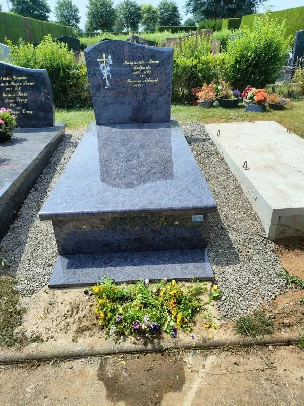 Monument funéraire en granit bleu Himalaya avec stèle gravée d'une croix et fleurs fraîches